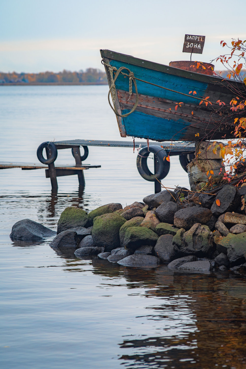 Старая лодка ждёт весны на каменном берегу
