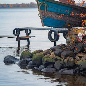 Старая лодка ждёт весны на каменном берегу