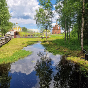 Красный кирпич и берёзы у тихой воды